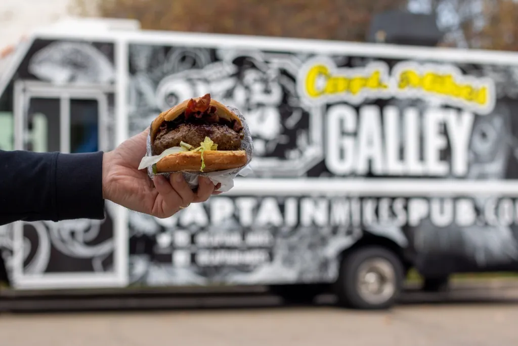 A Capt. Mike's burger held up in front of the Galley truck