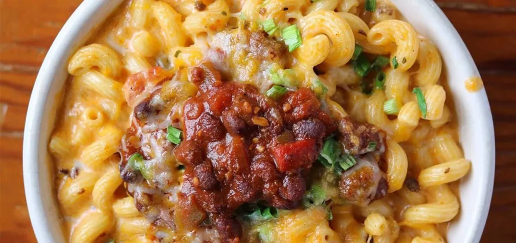 Mac 'n cheese topped with beer chili and green onion