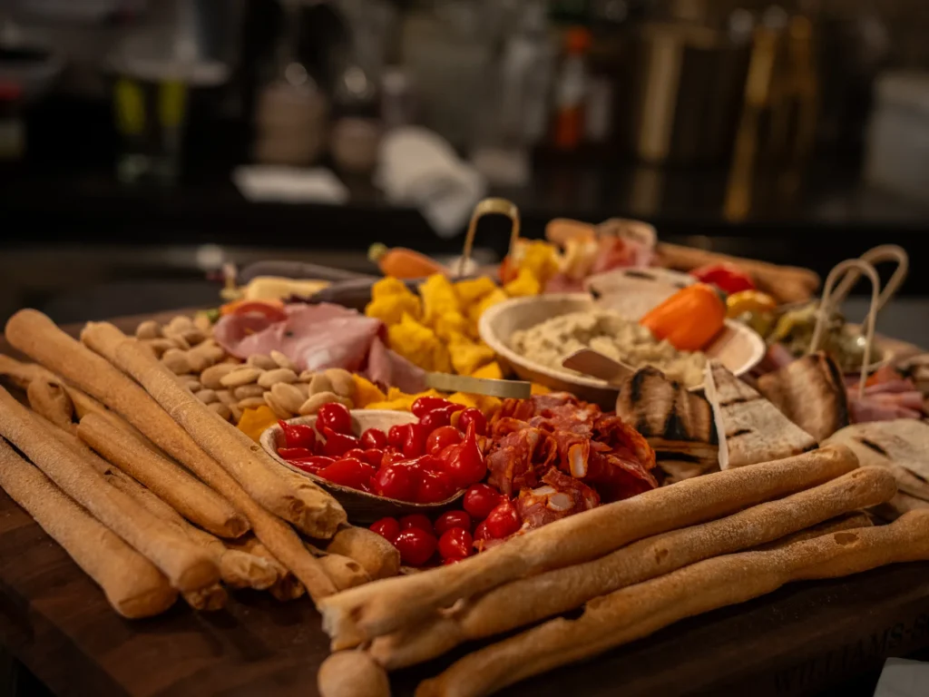 A grazing board from Portside Catering: breadsticks, cured meats, cheese, tomatoes and dips