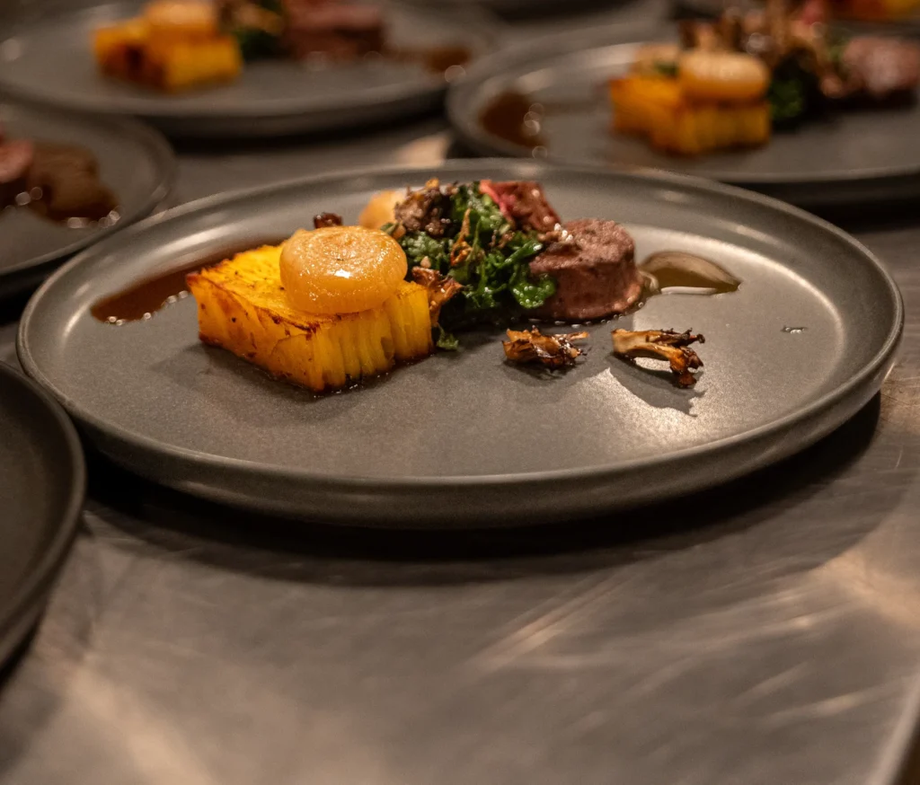 Plated dinners lined up on the pass at a Portside Catering event